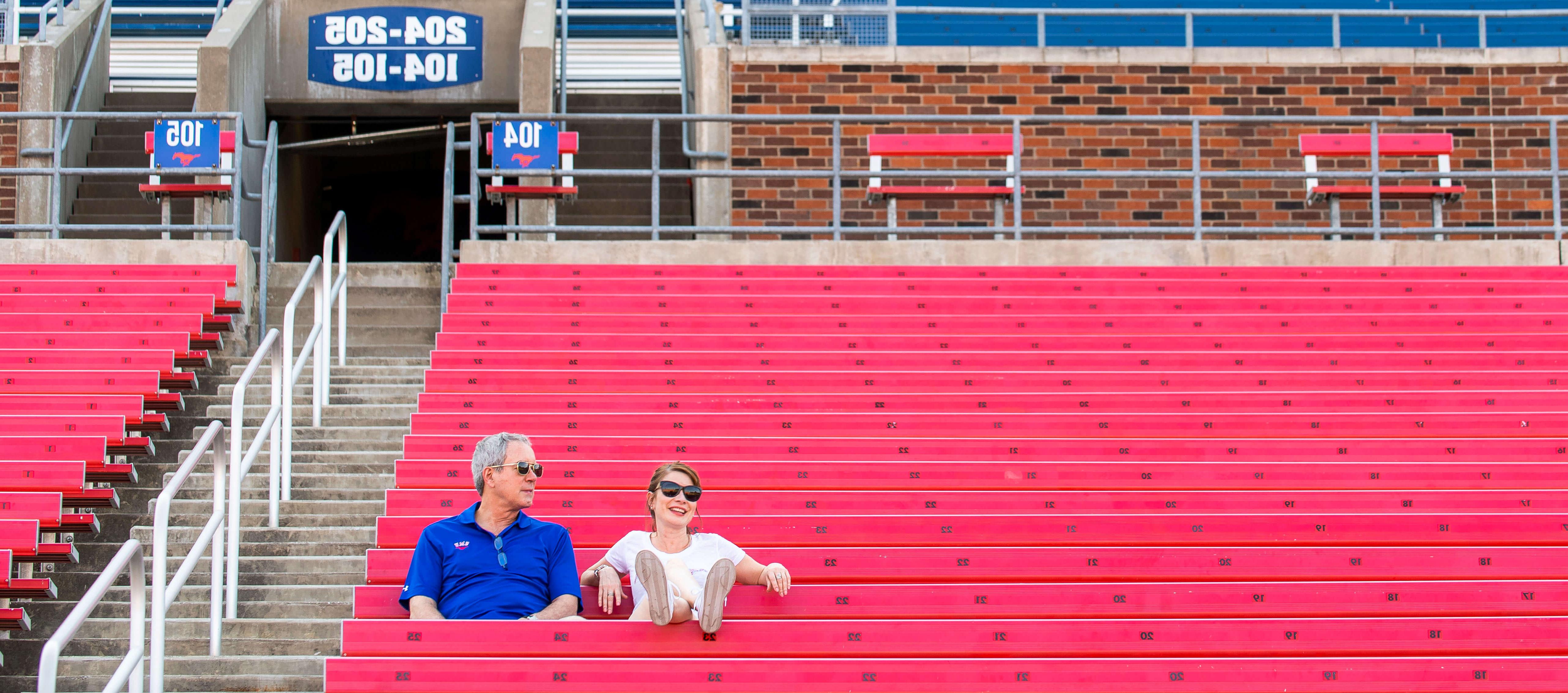 Two people sitting at Ford Stadium