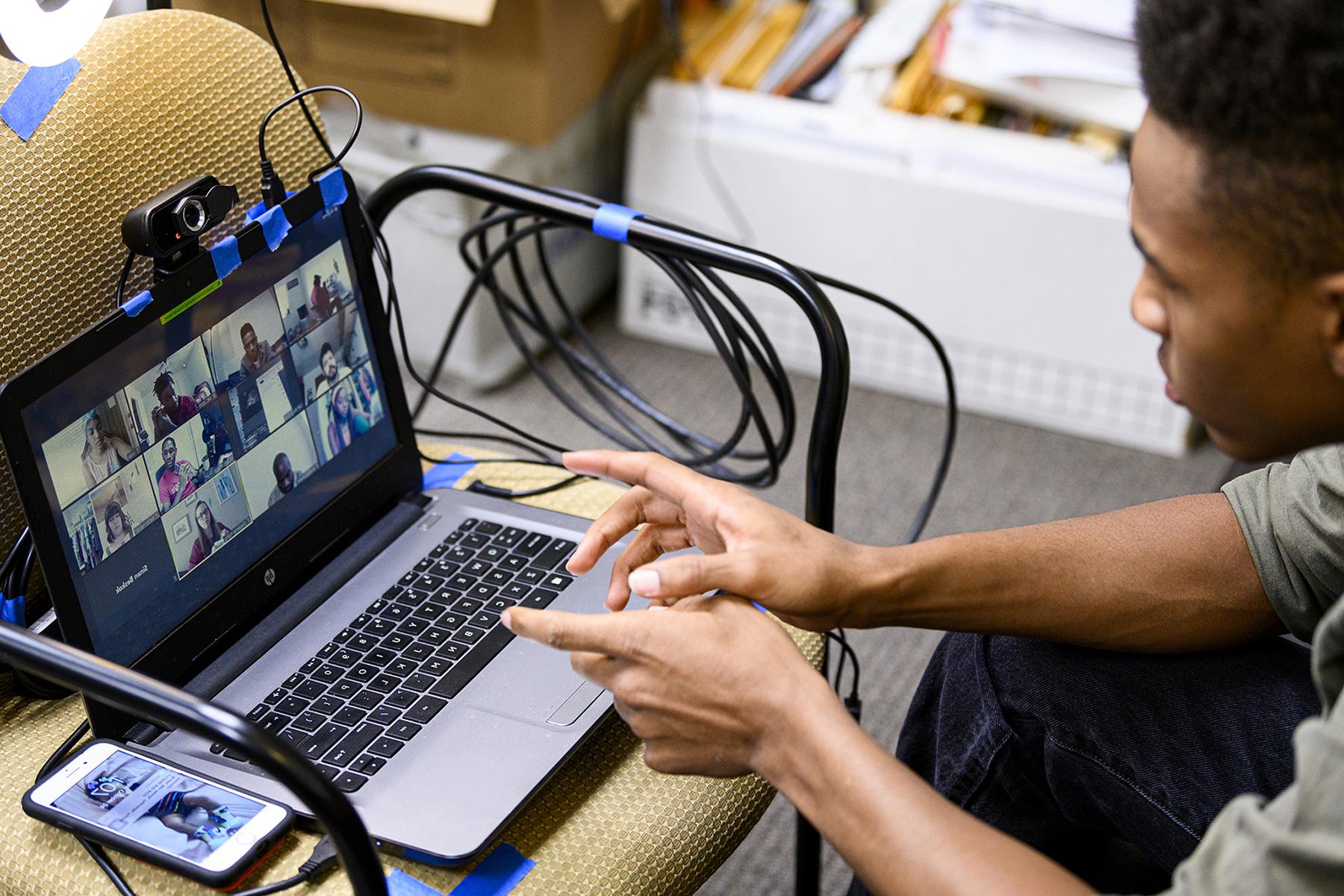 black student editing film on a laptop