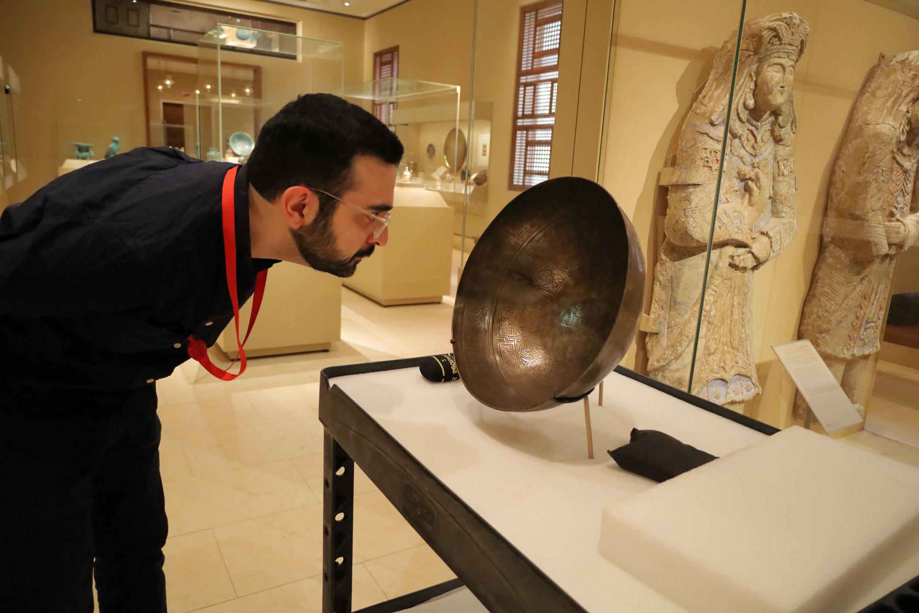 Sixth year Ph.D. student Arvin Maghsoudlou examines a piece of work for his art history program.